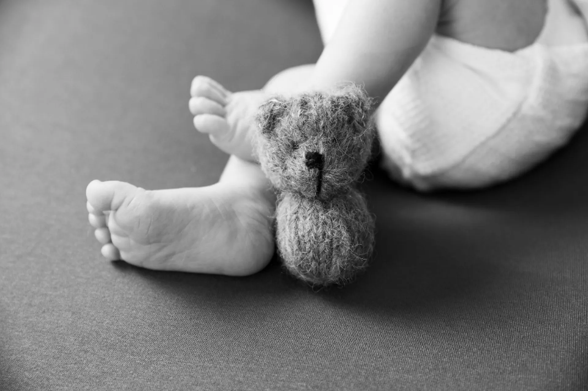 Újszülött baba lábacskái mackóval — természetes újszülött fotózás